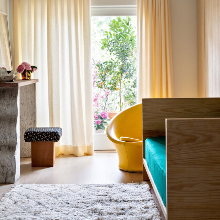 a bedroom with a bed, a chair and a window