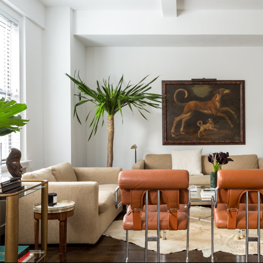 a living room filled with furniture and a painting on the wall