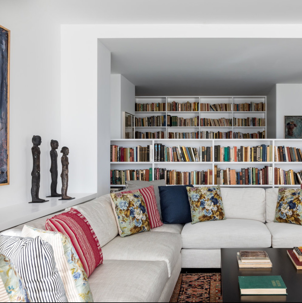 a living room filled with lots of books and furniture