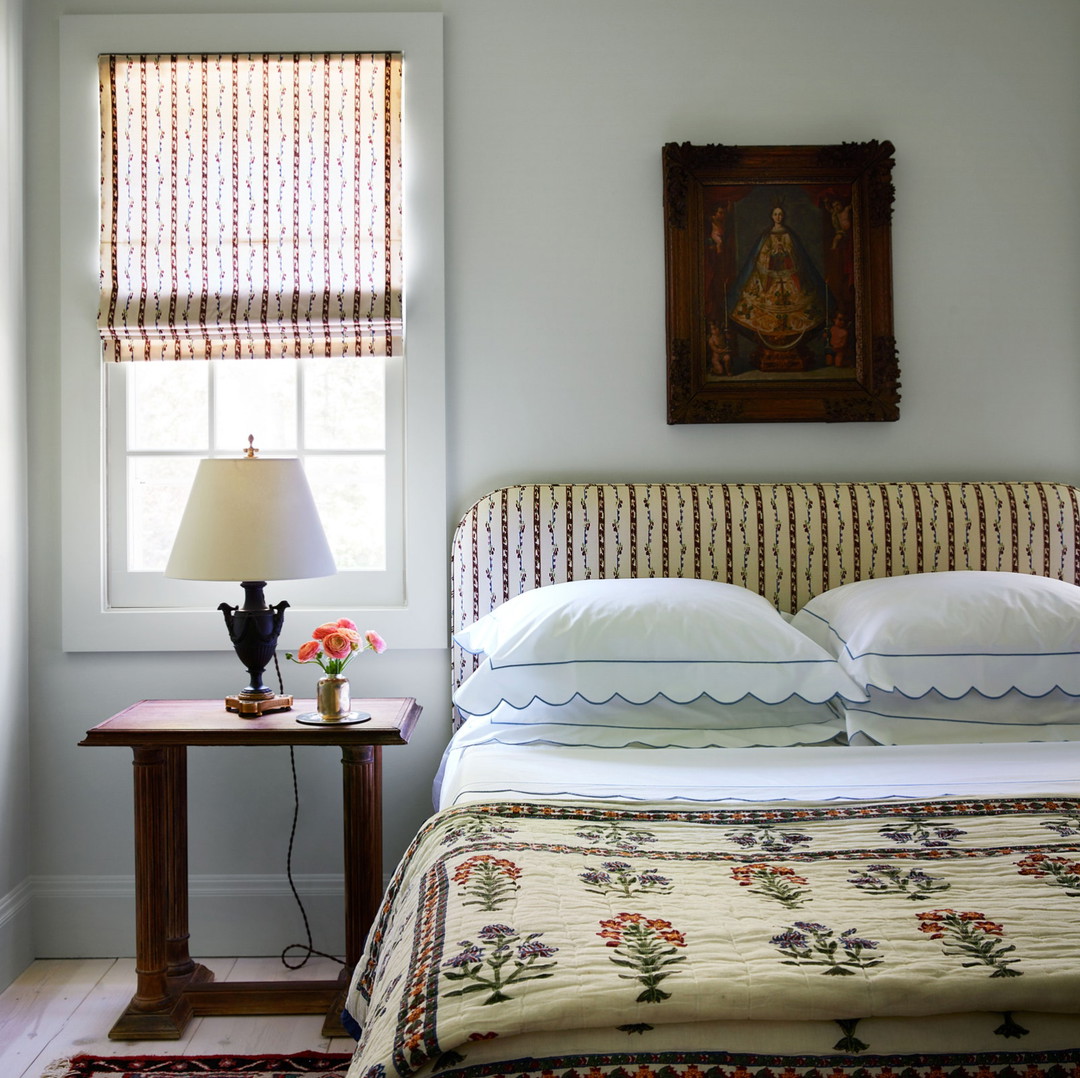 a bed sitting under a window next to a lamp