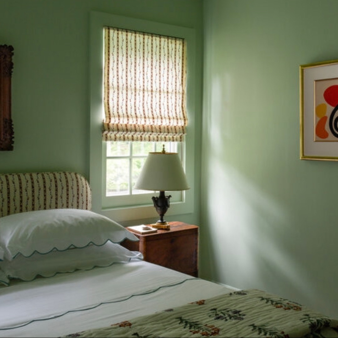 a bedroom with green walls and a white bed