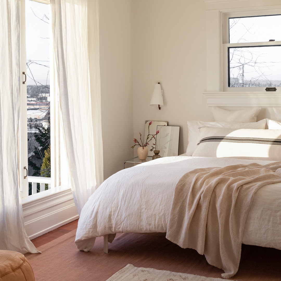 a bedroom with a white bed and a window