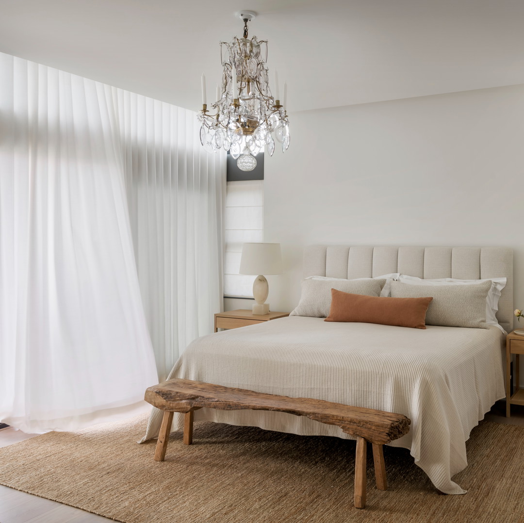 a bedroom with a large bed and a chandelier