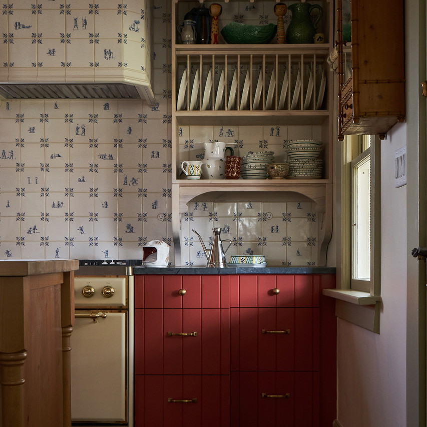 a kitchen with red cabinets and white walls