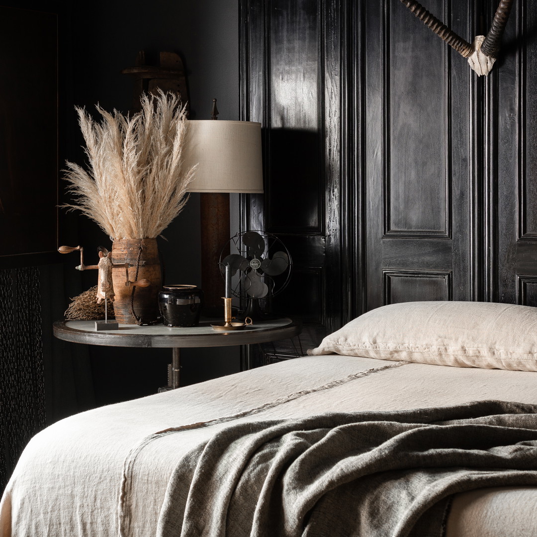 a bedroom with black walls and a white bed