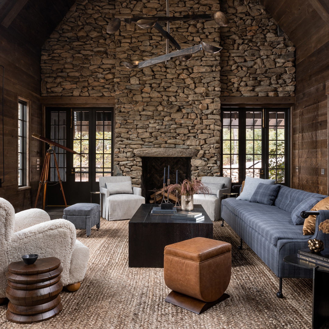 a living room filled with furniture and a stone fireplace