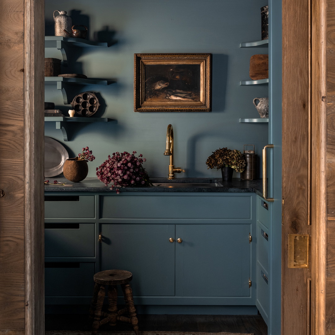 a kitchen with blue walls and a wooden door