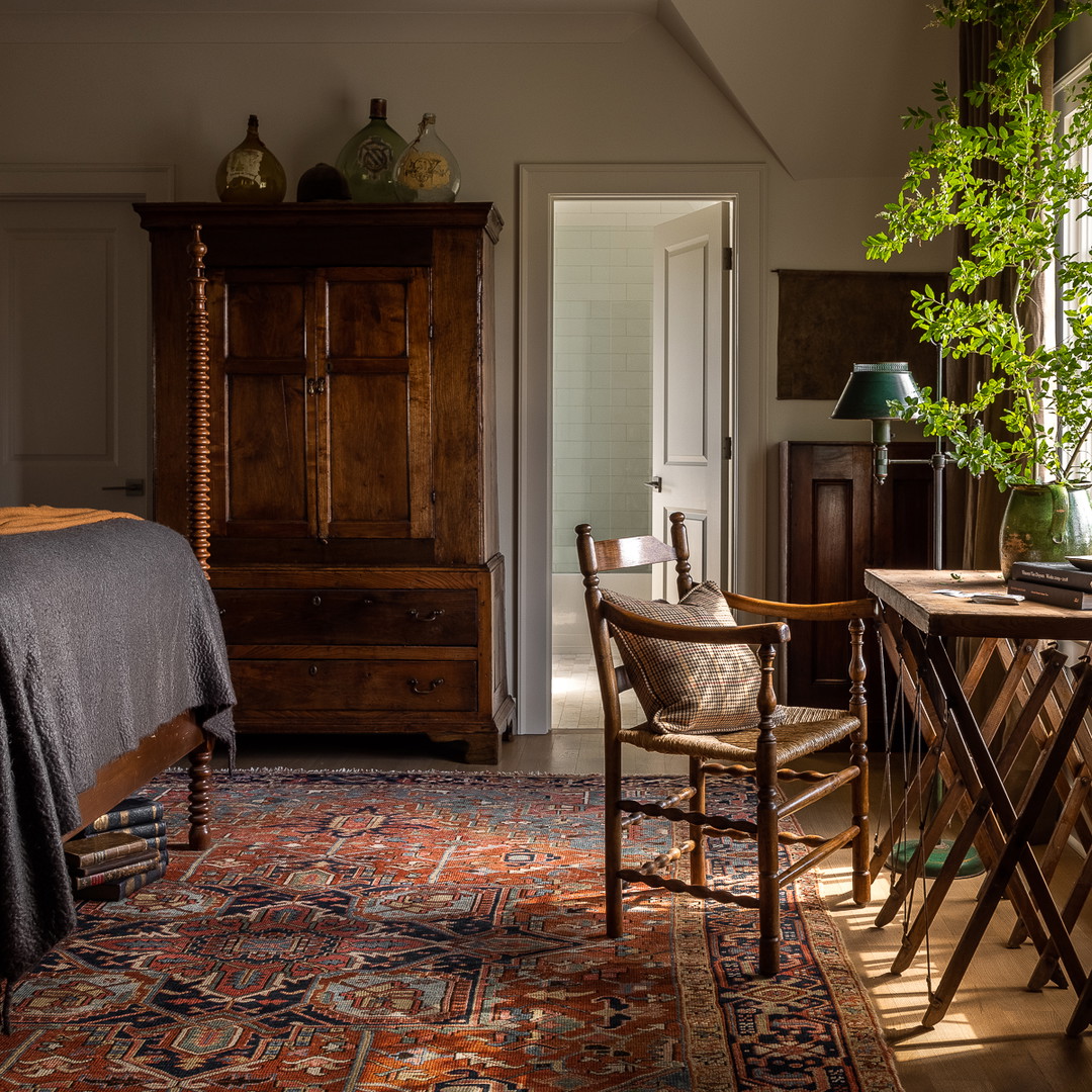 a bedroom with a bed, a dresser, and a chair