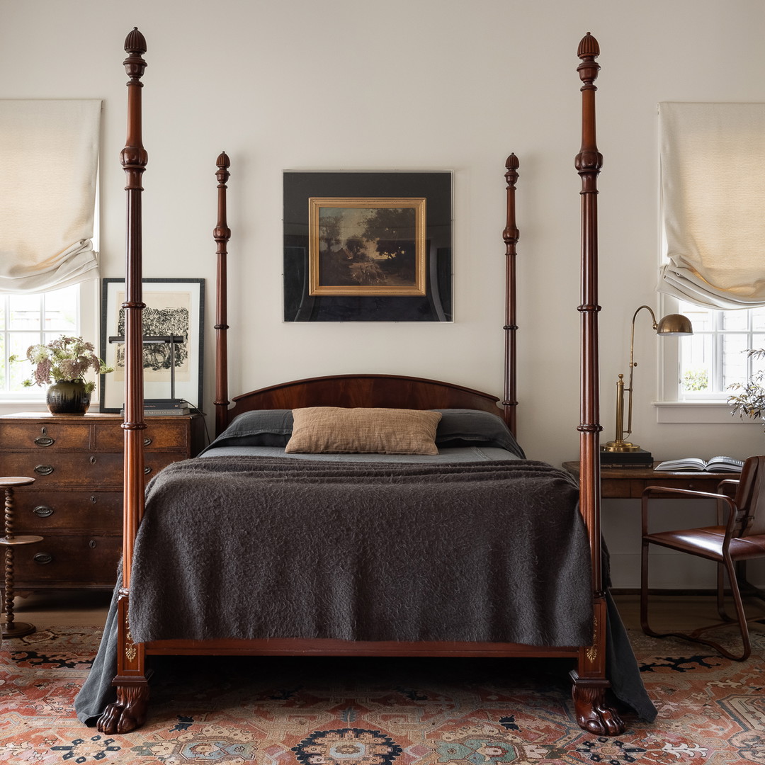 a bed sitting in a bedroom next to a chair