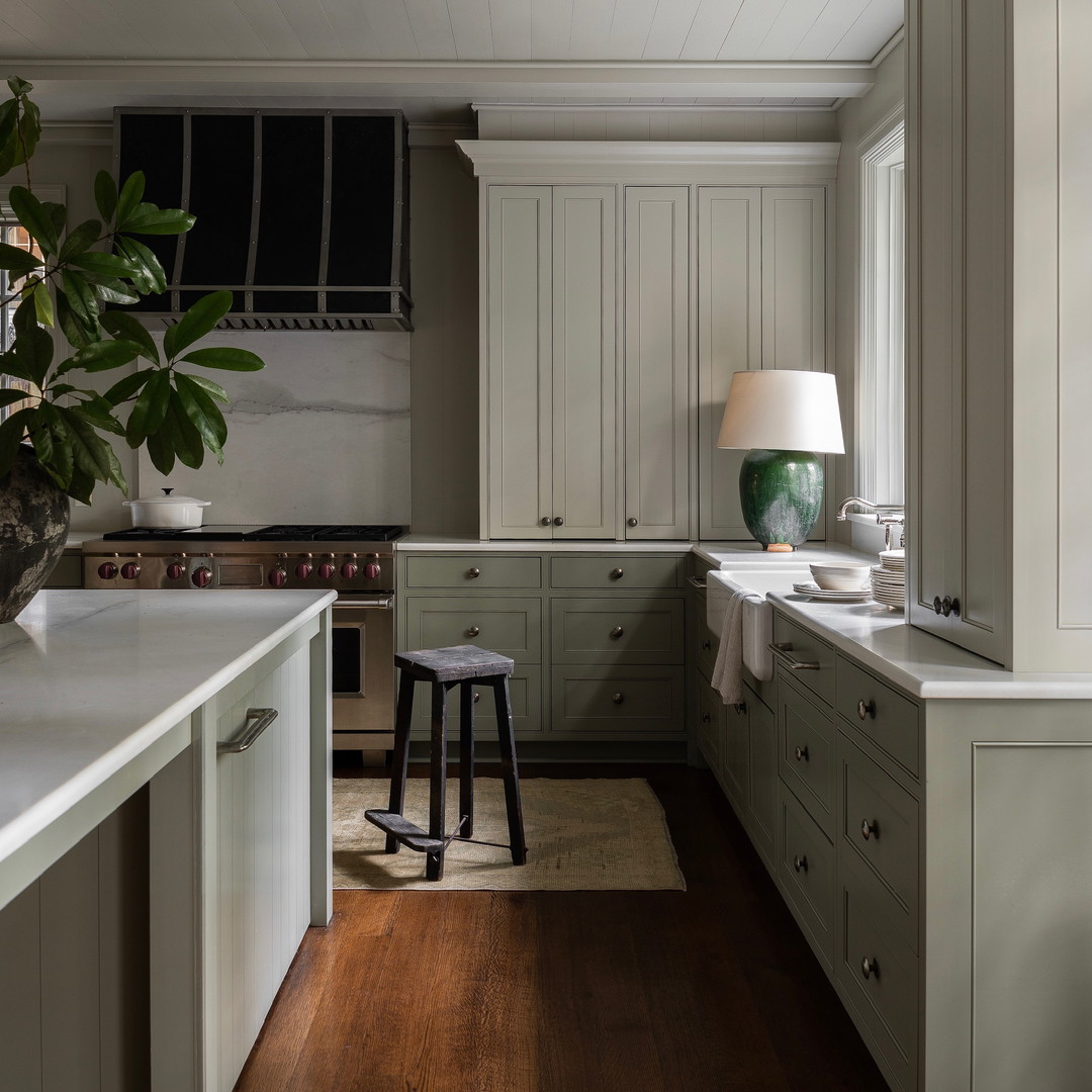 a kitchen with white cabinets and a wooden floor