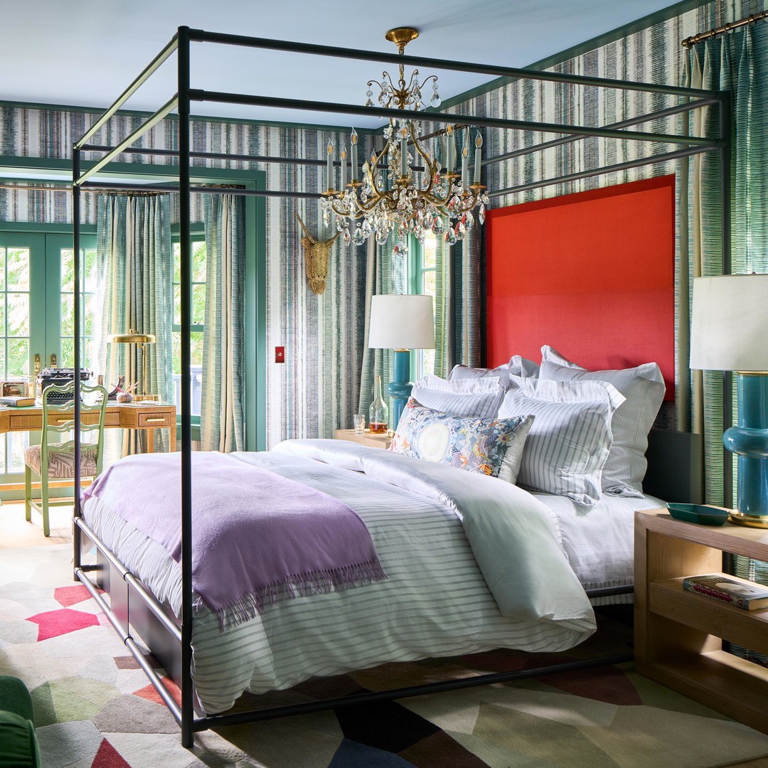 a bedroom with a four poster bed and colorful walls