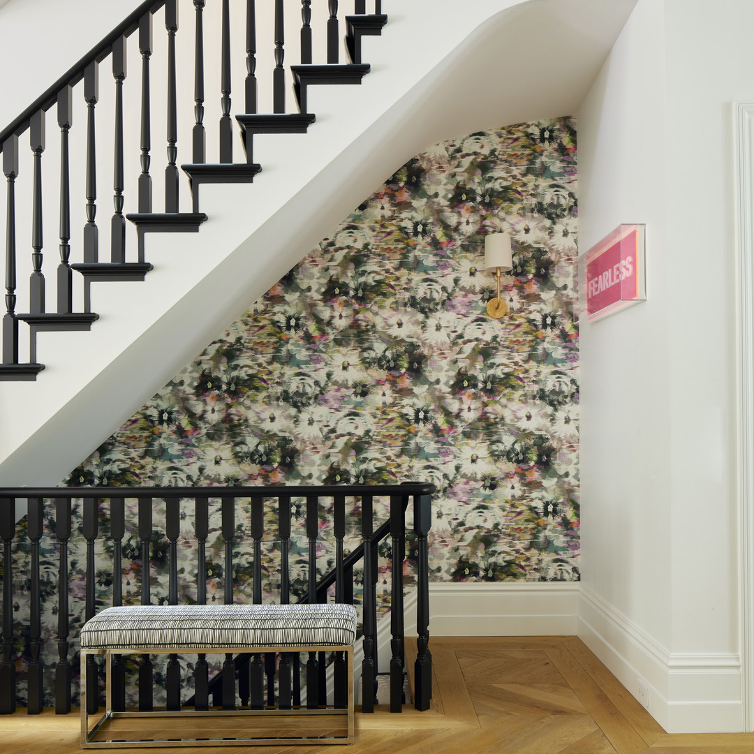 a stair case next to a floral wallpaper