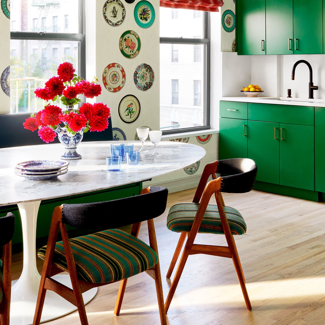 a kitchen with green cabinets and a white table