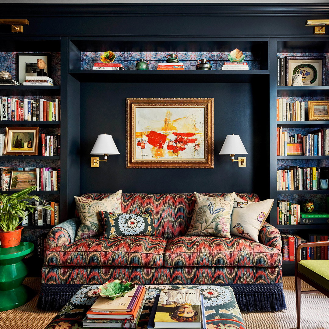 a living room filled with lots of books and furniture