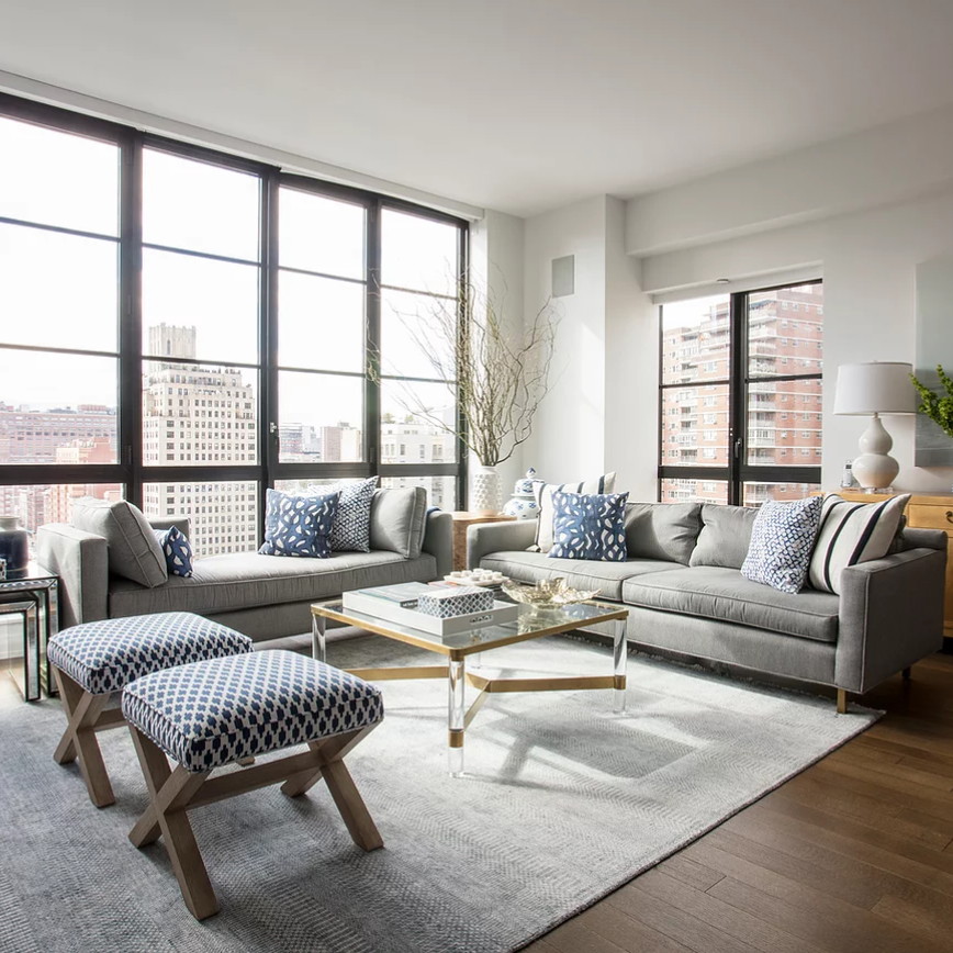 a living room filled with furniture and large windows