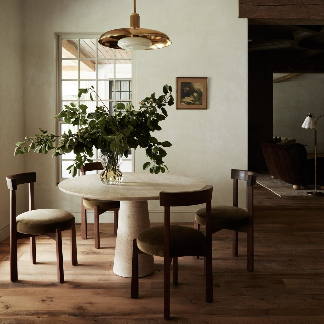 a dining room with a table and chairs and a potted plant