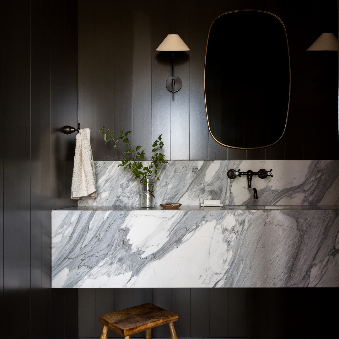 a bathroom with a marble sink and stool