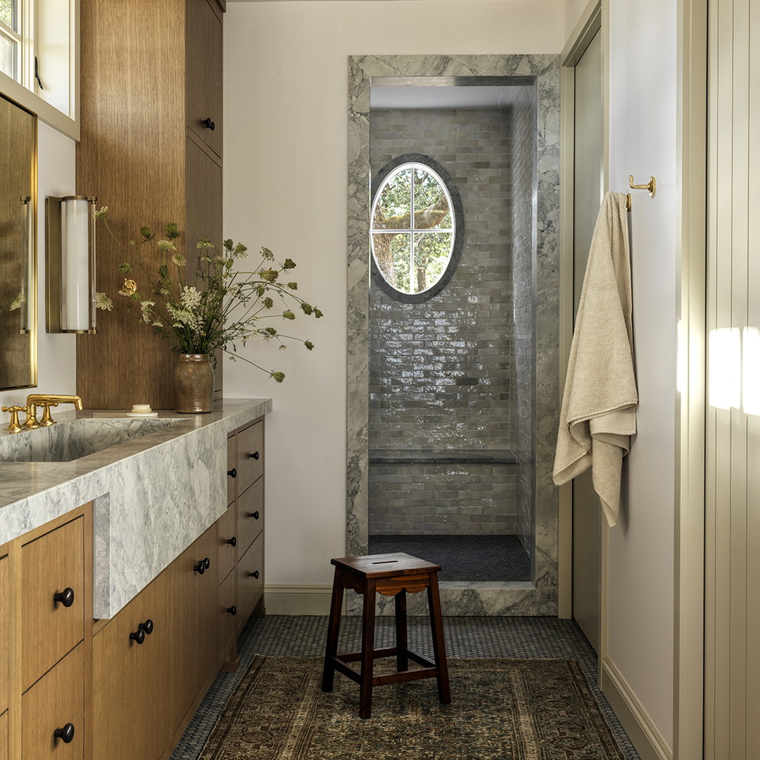 a bathroom with a sink, mirror and a stool