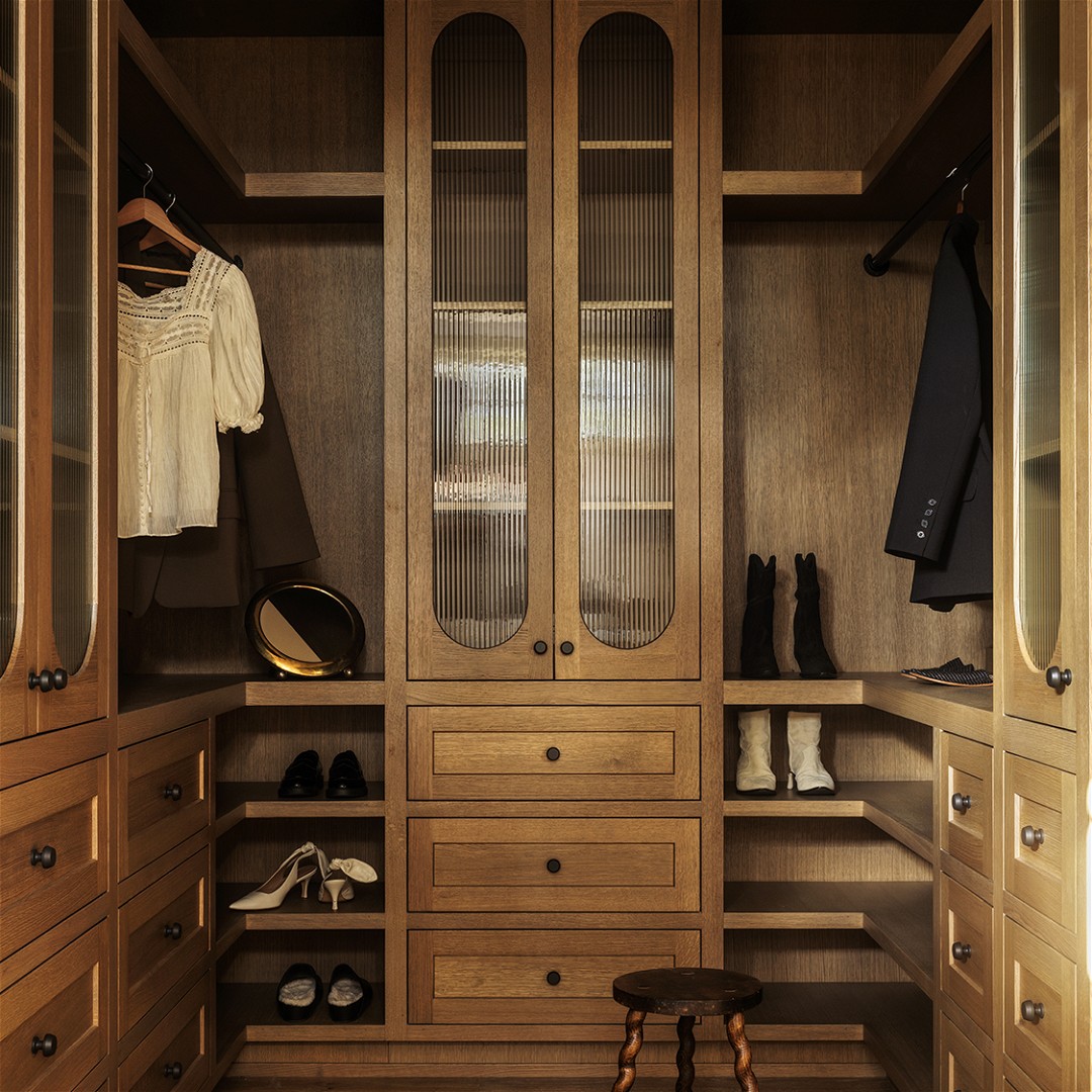 a walk - in closet with wooden cabinets and shoes