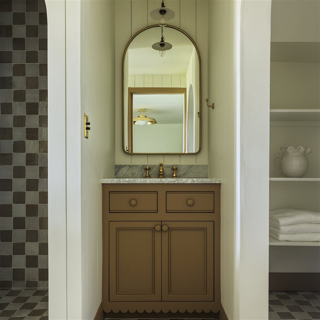 a bathroom with a checkered floor and a large mirror