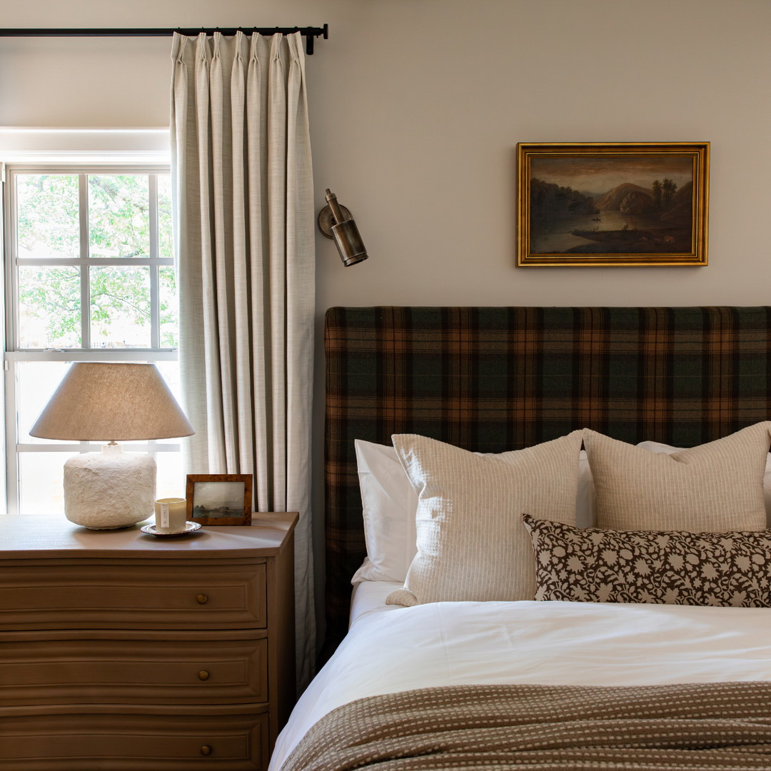 a bedroom with a bed, nightstand, and window