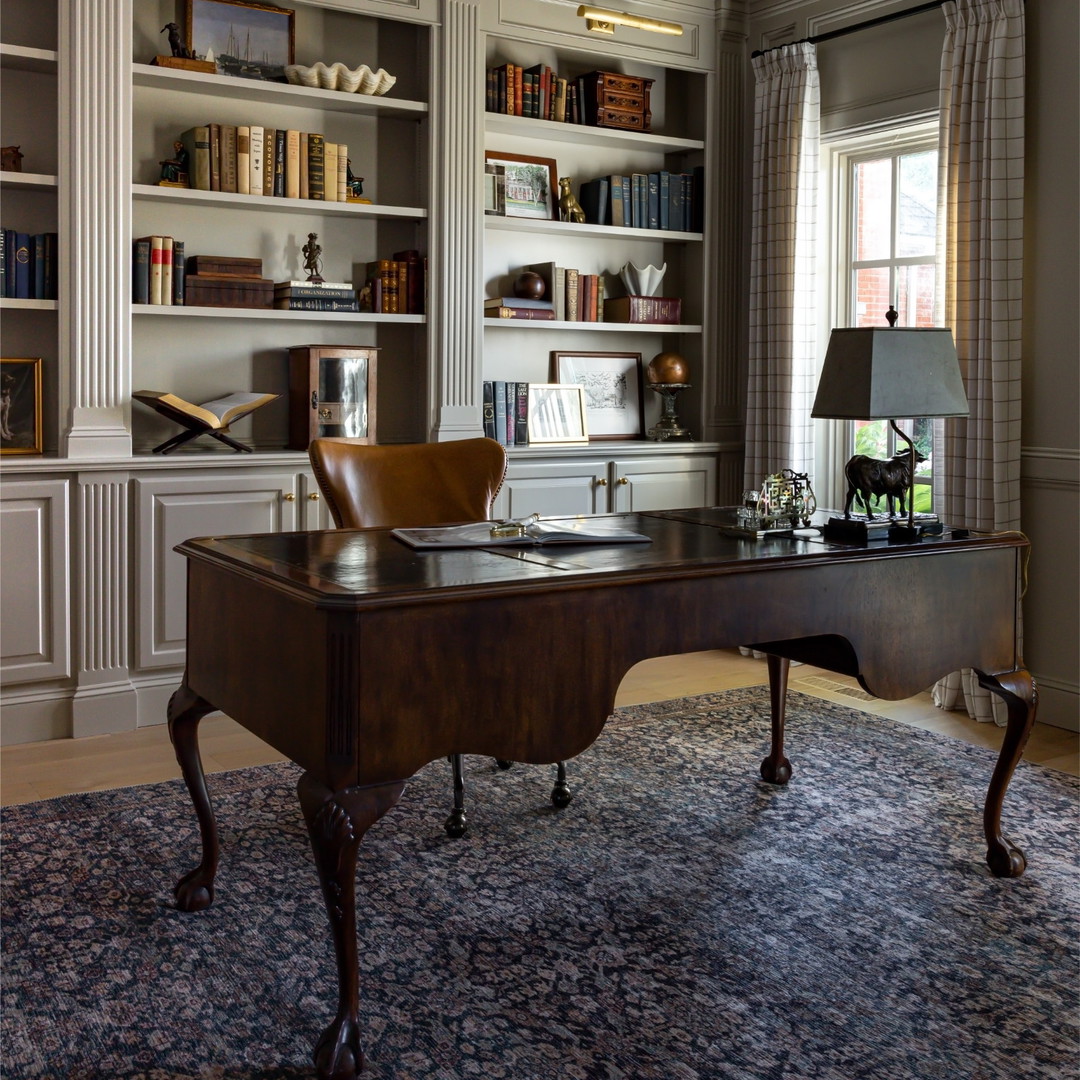 a home office with a desk and bookcases