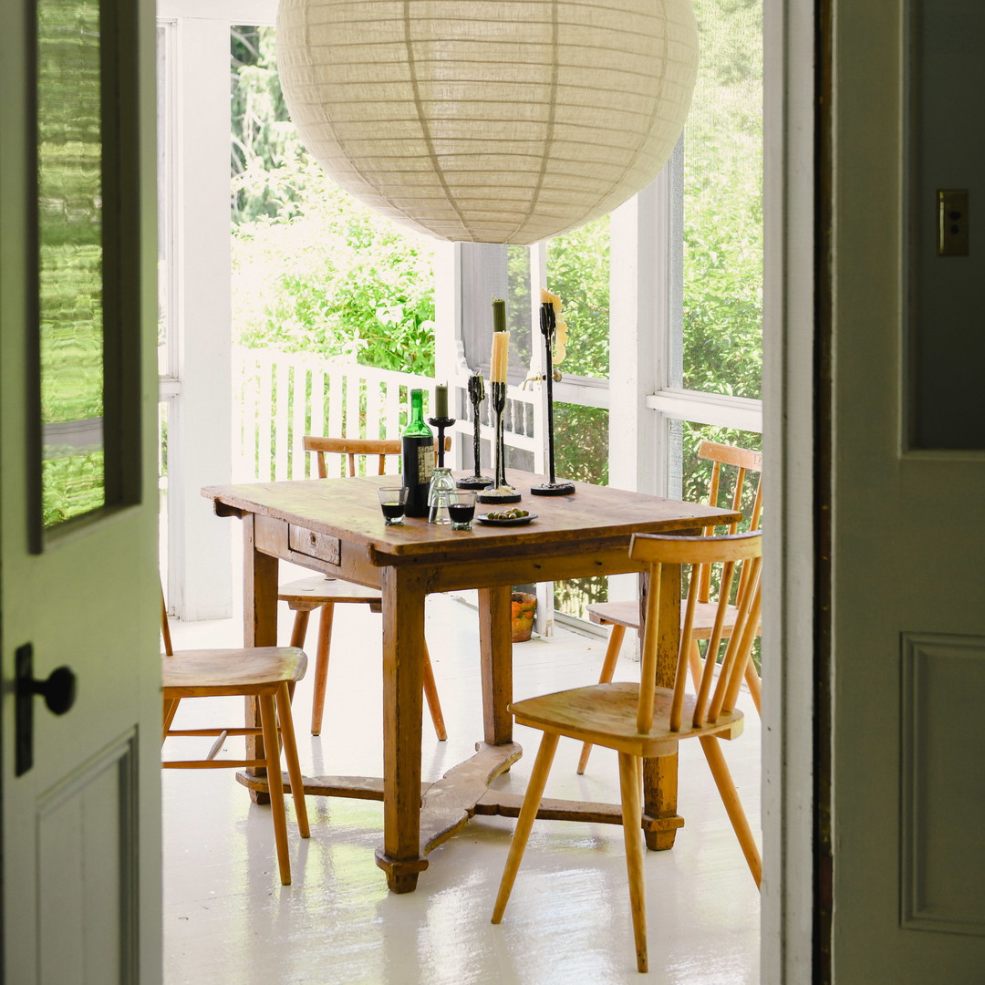 a dining room table with a lantern hanging over it