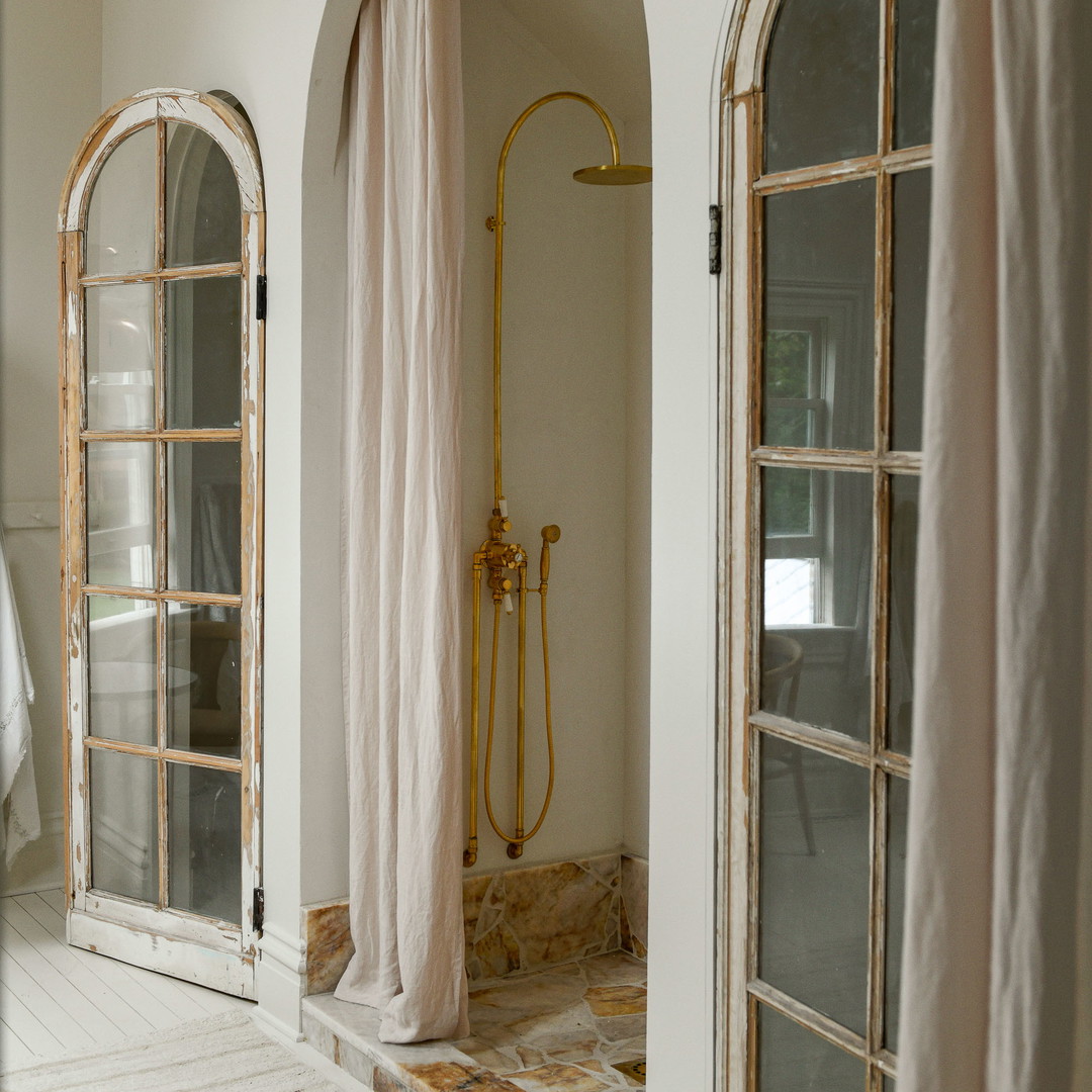 a bathroom with a shower and two windows