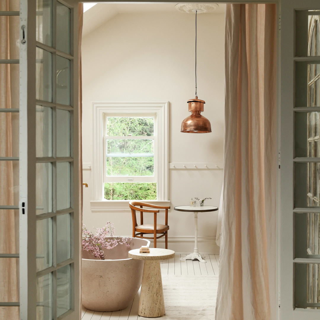 a bathroom with a tub and a chair in it