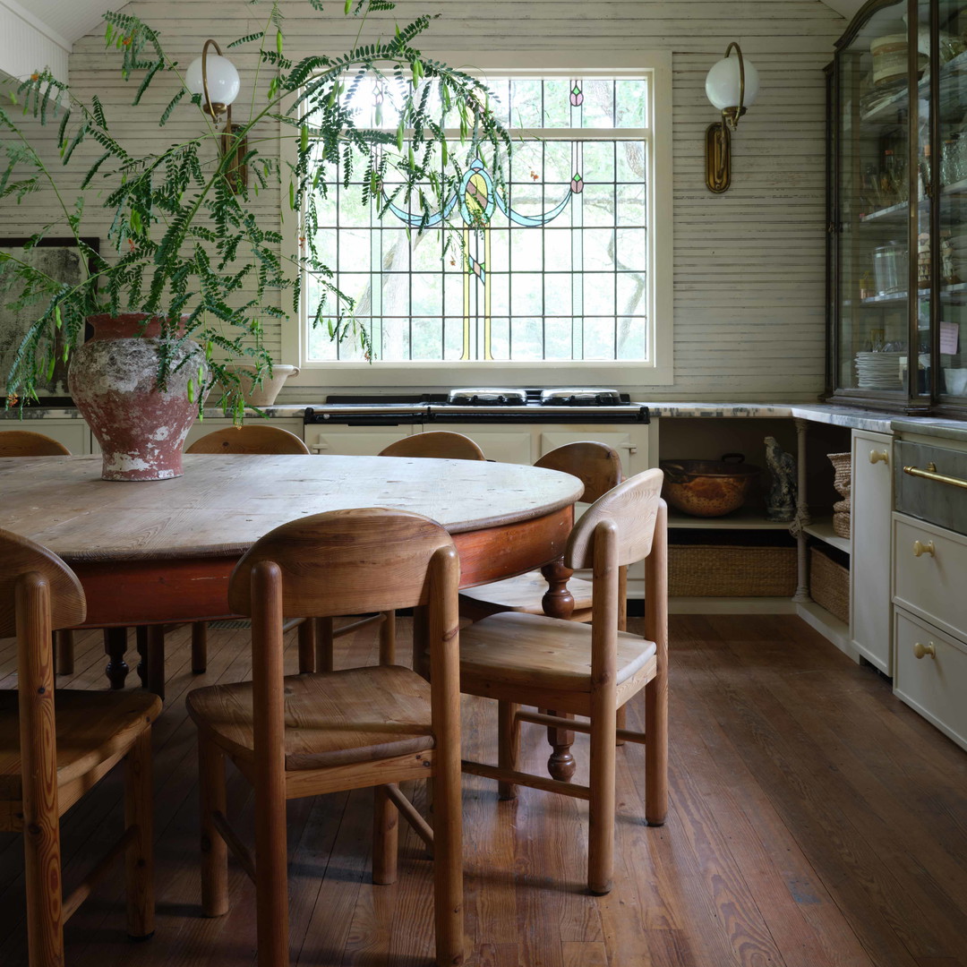 a dining room table with chairs and a potted plant