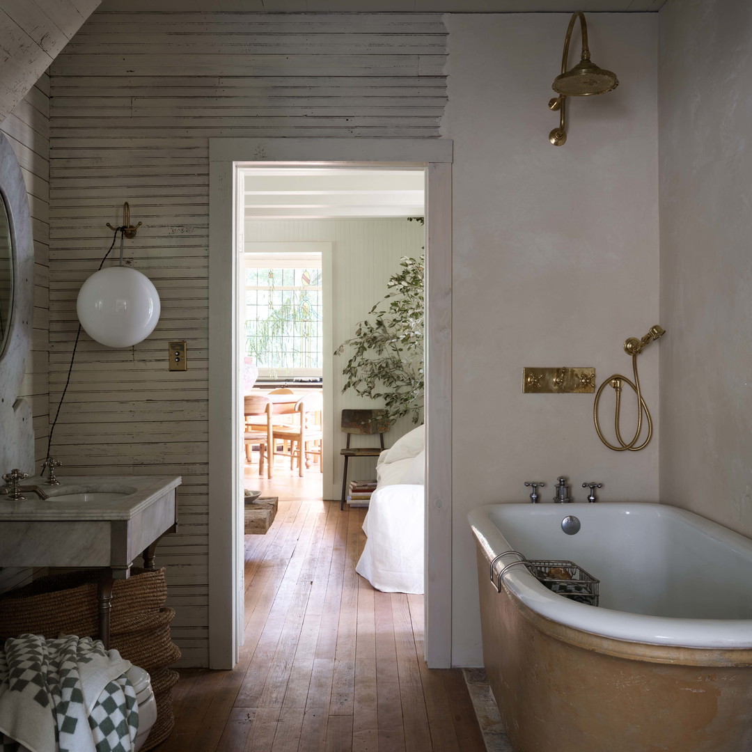 a bathroom with a bathtub, sink and mirror