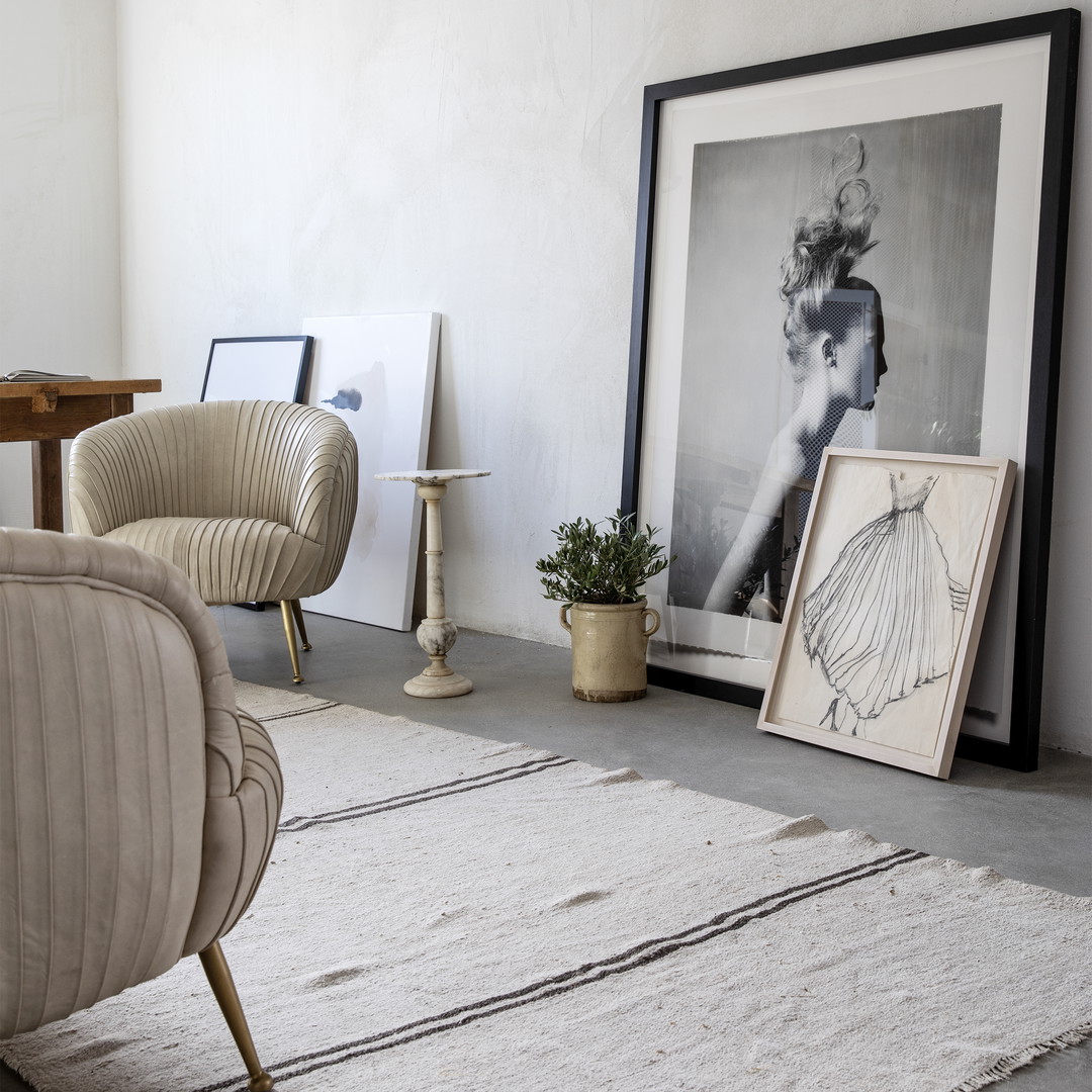 a living room with a chair and a picture on the wall