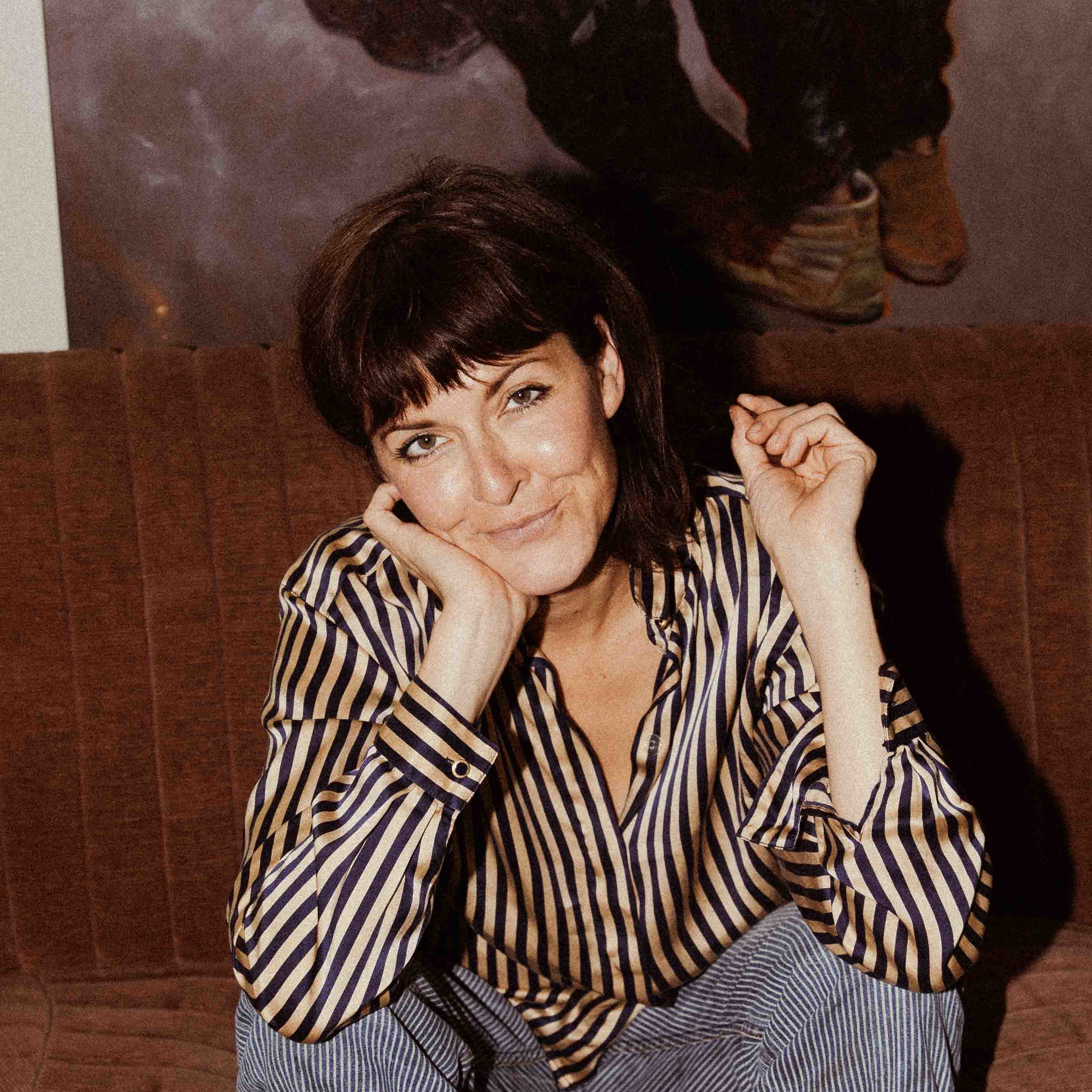 a woman sitting on top of a brown couch