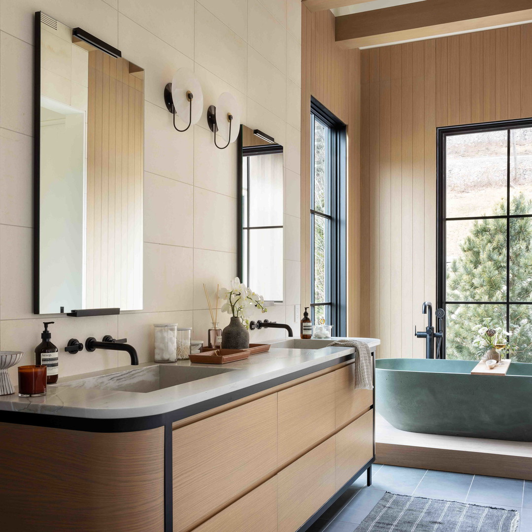 a bathroom with a tub, sink, and mirror