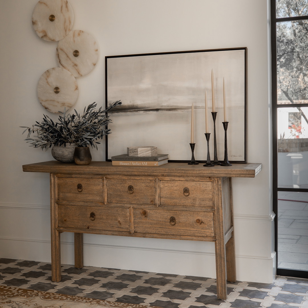 a wooden table with a vase and candles on top of it