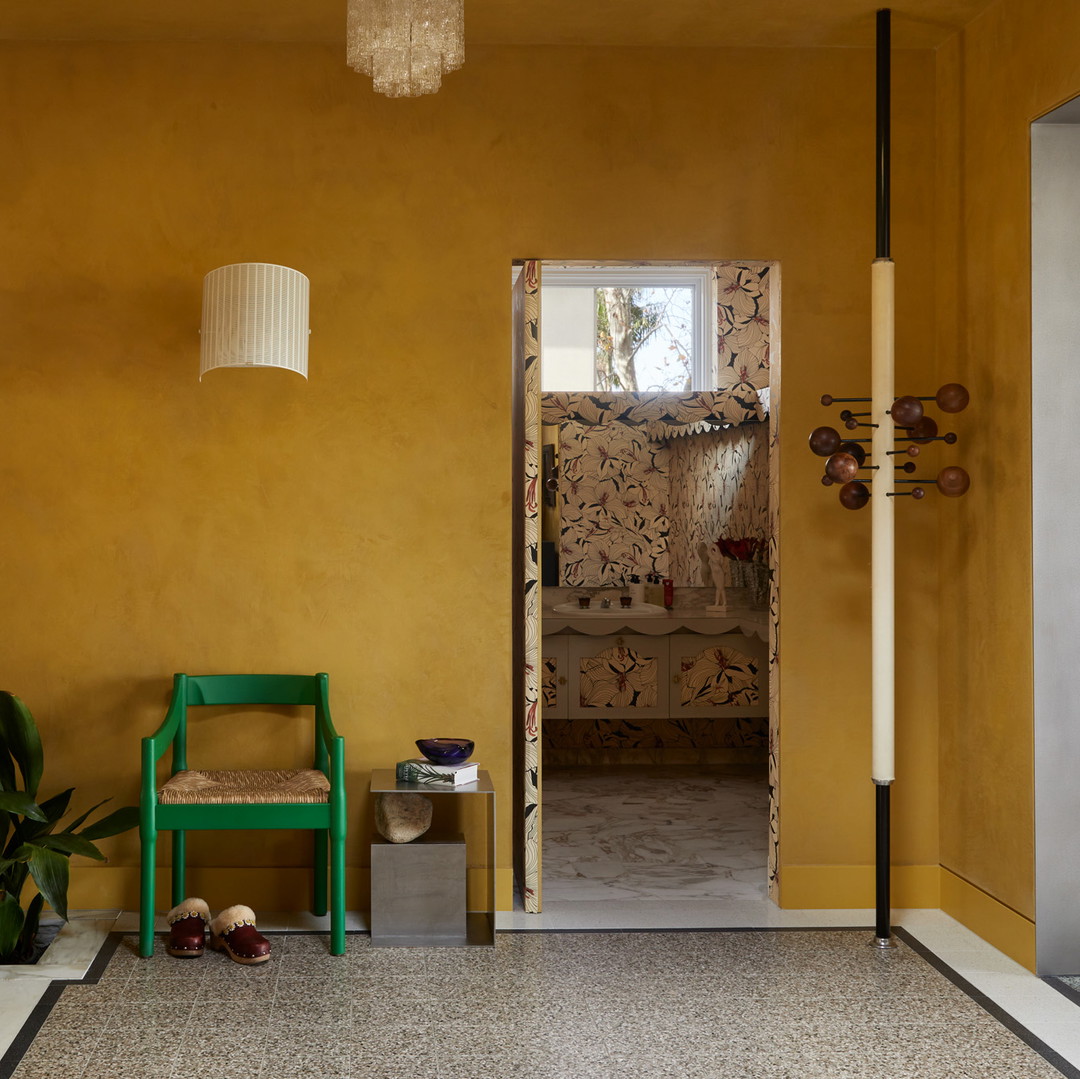 a room with a yellow wall and a green chair