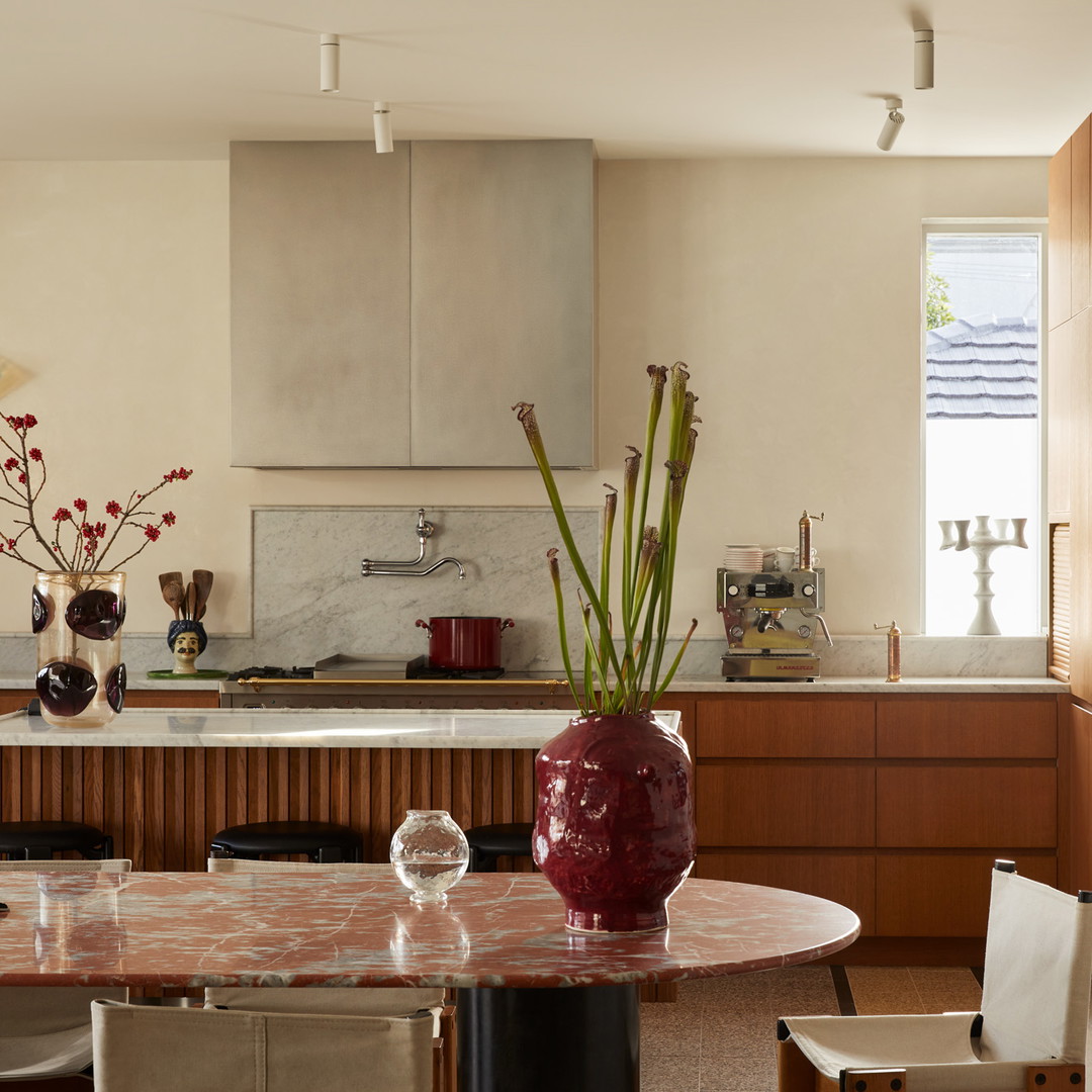 a kitchen with a table and chairs and a vase with flowers in it