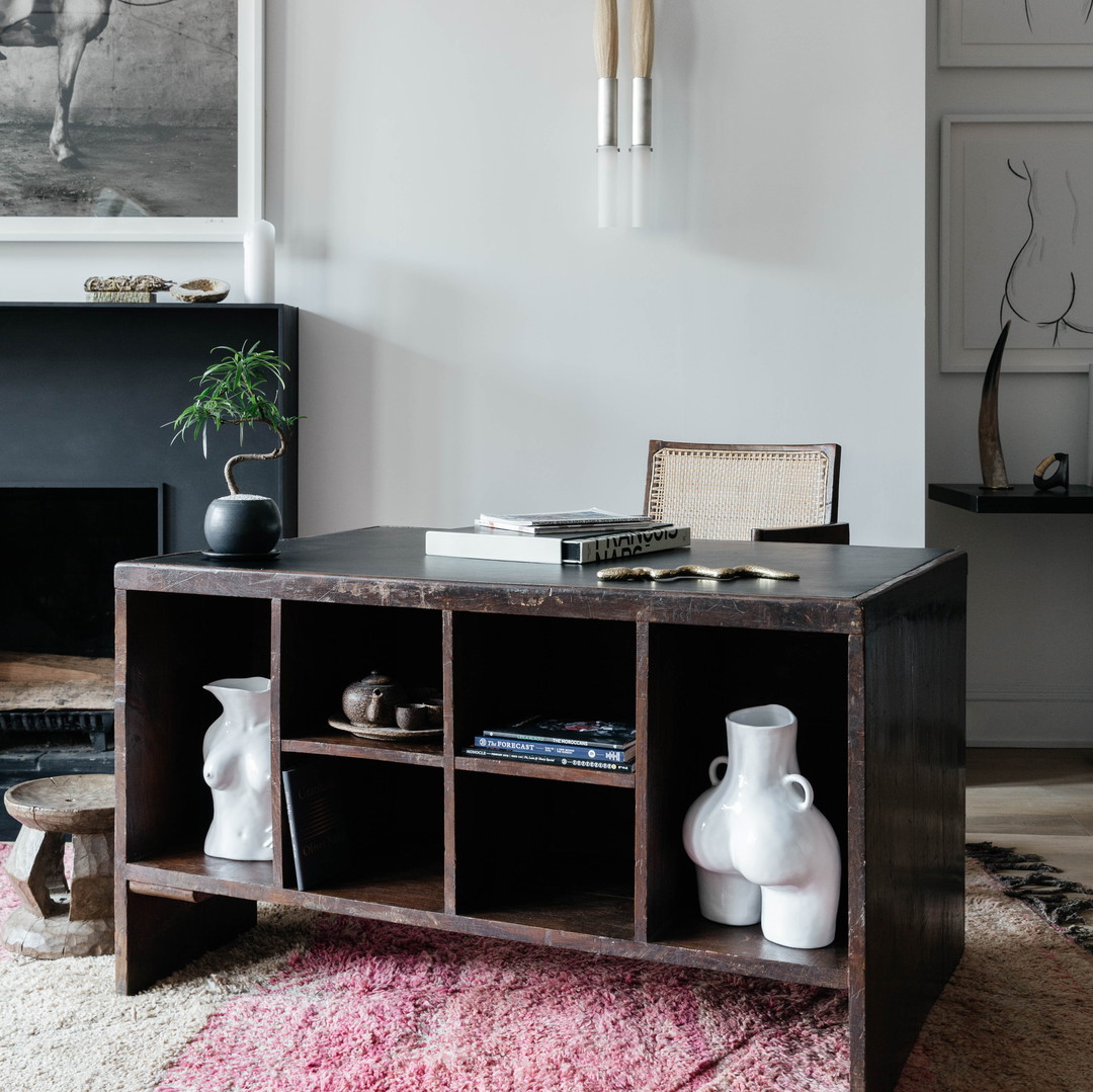 a living room with a rug and a table with vases on it