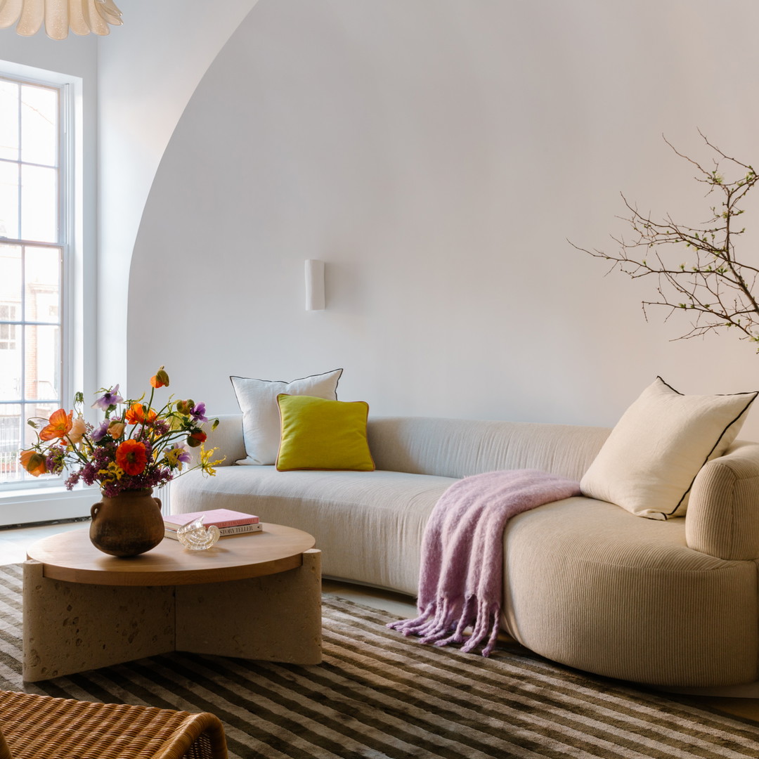 a living room filled with furniture and a vase of flowers