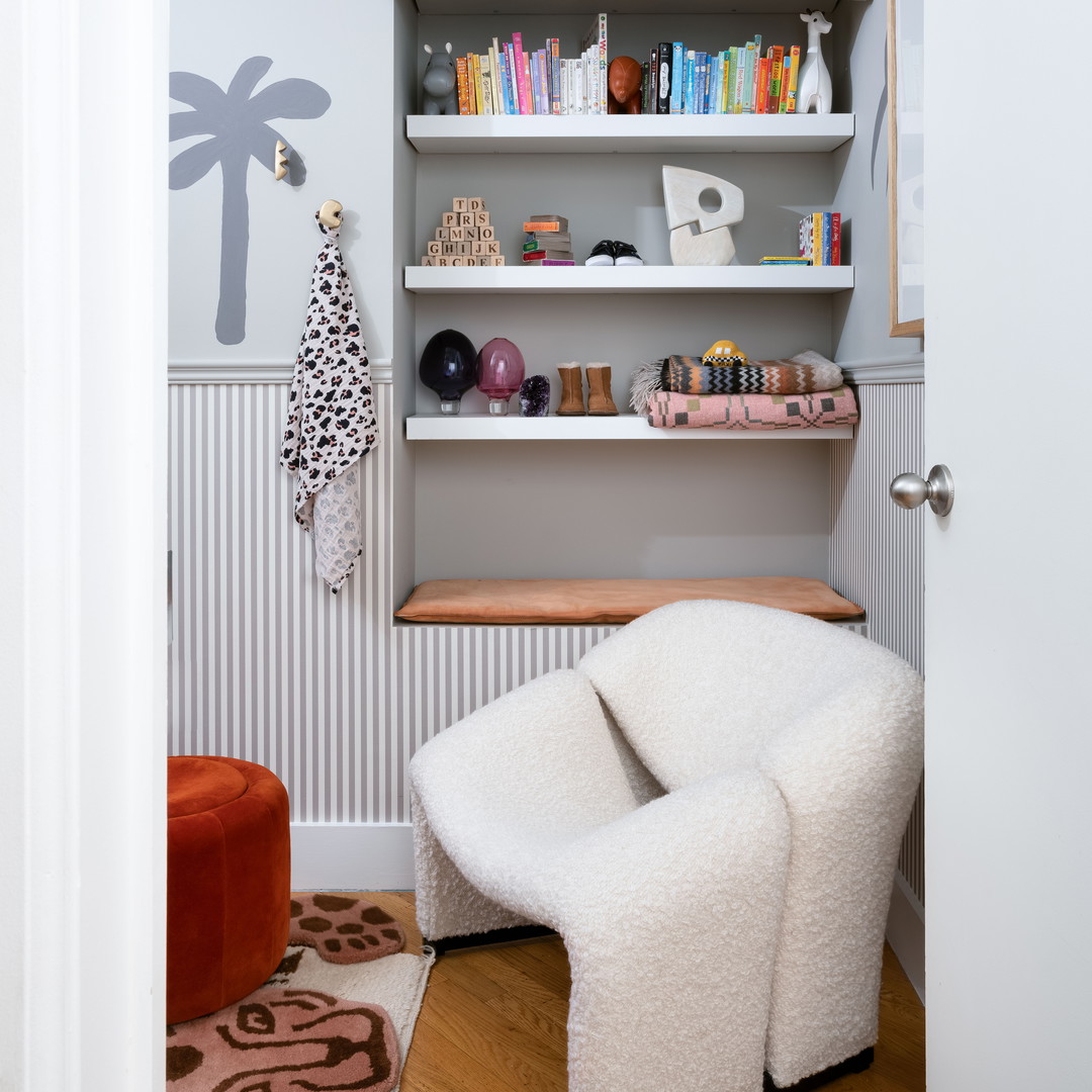 a white chair sitting in front of a book shelf