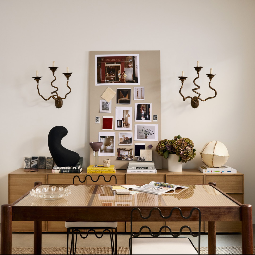 a dining room with a table, chairs and pictures on the wall