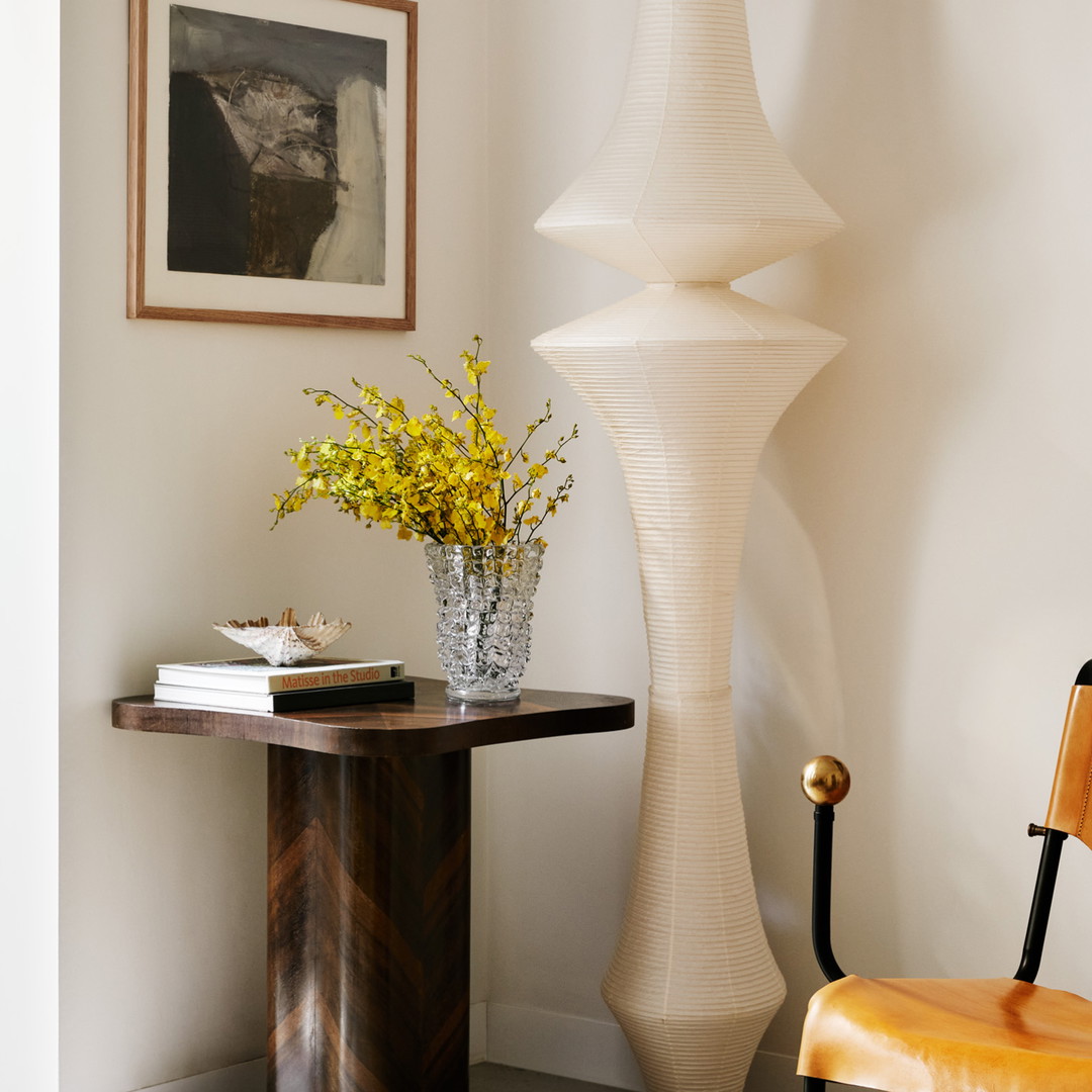 a room with a chair and a vase with flowers