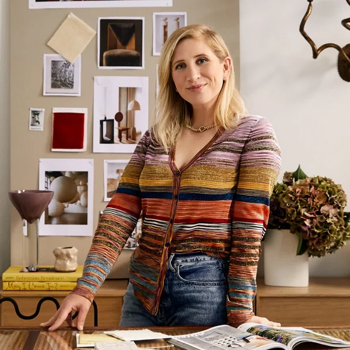 a woman standing at a table with a magazine on it