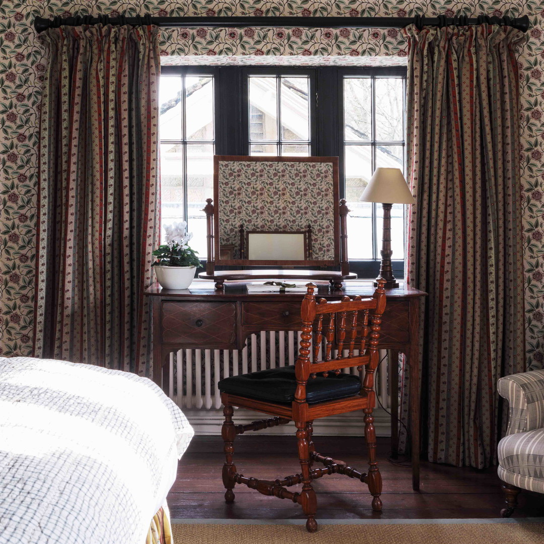 a bedroom with a bed, chair, desk and window