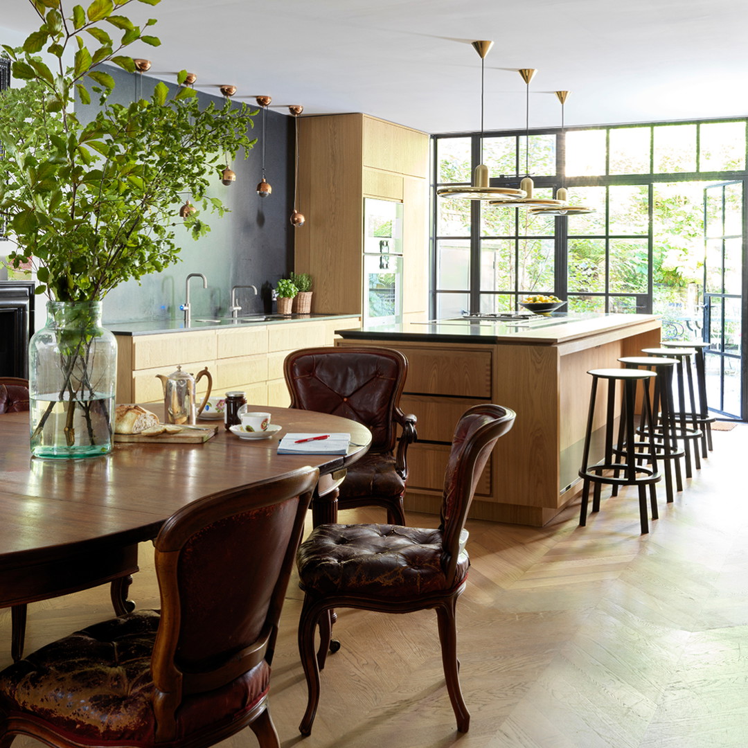 a dining room table with chairs and a vase of flowers