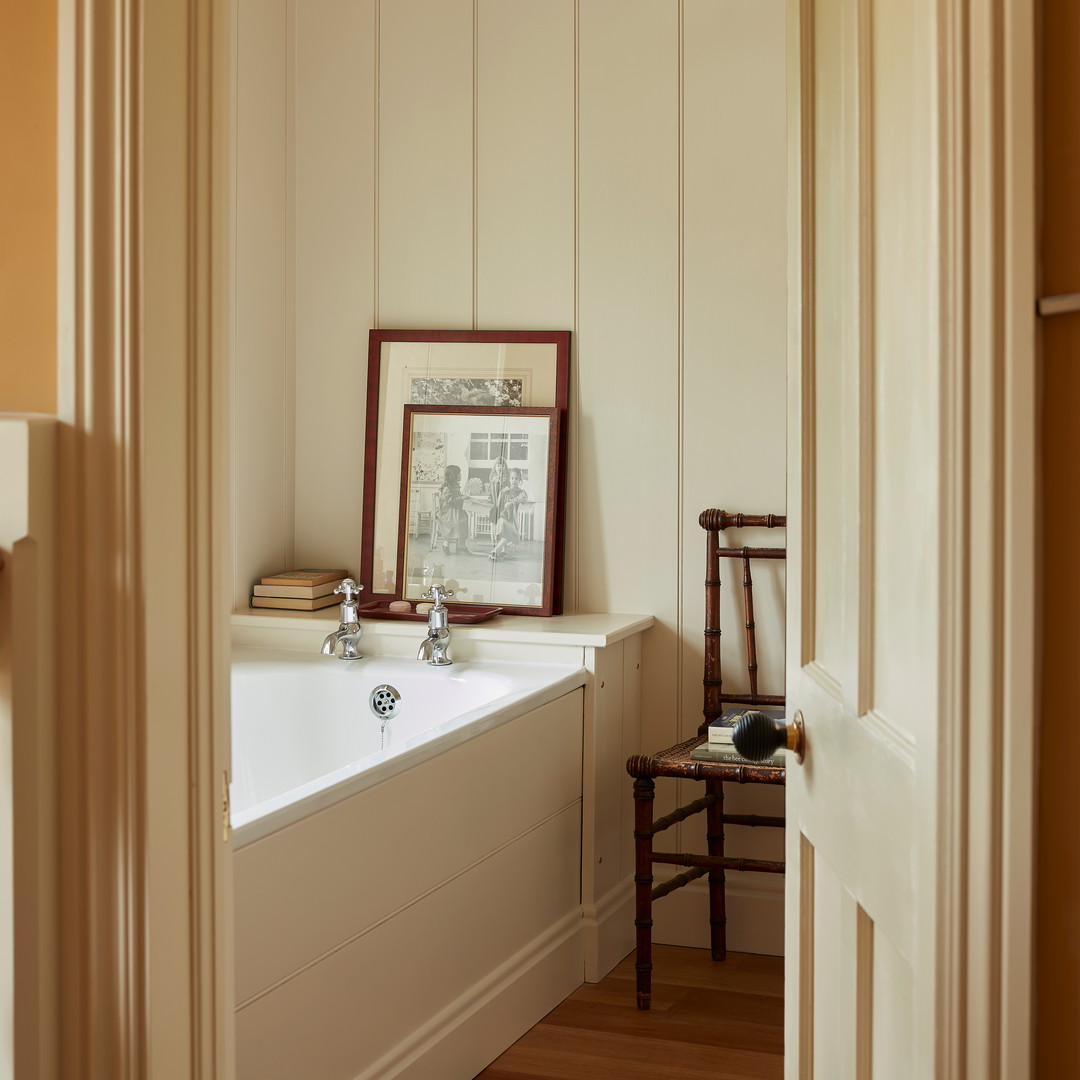 a bathroom with a bathtub and a chair