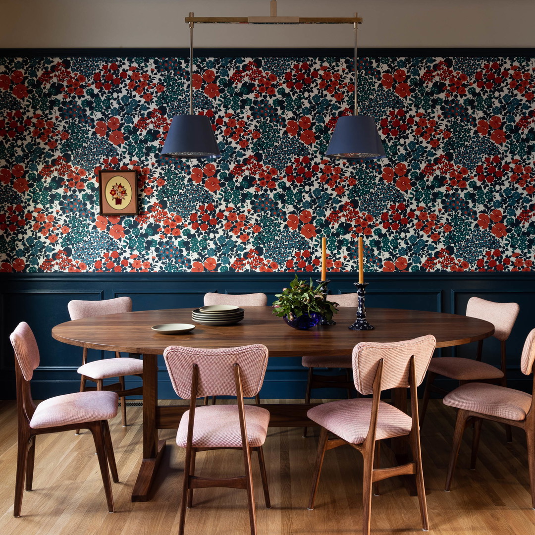 a dining room with a wooden table surrounded by pink chairs