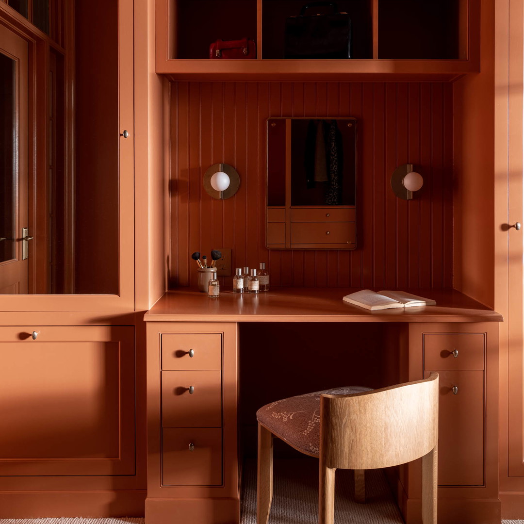 a desk with a stool and a mirror in a room