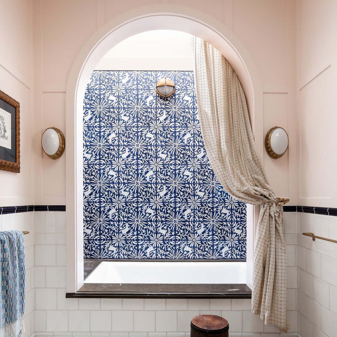 a blue and white tiled bathroom with a window