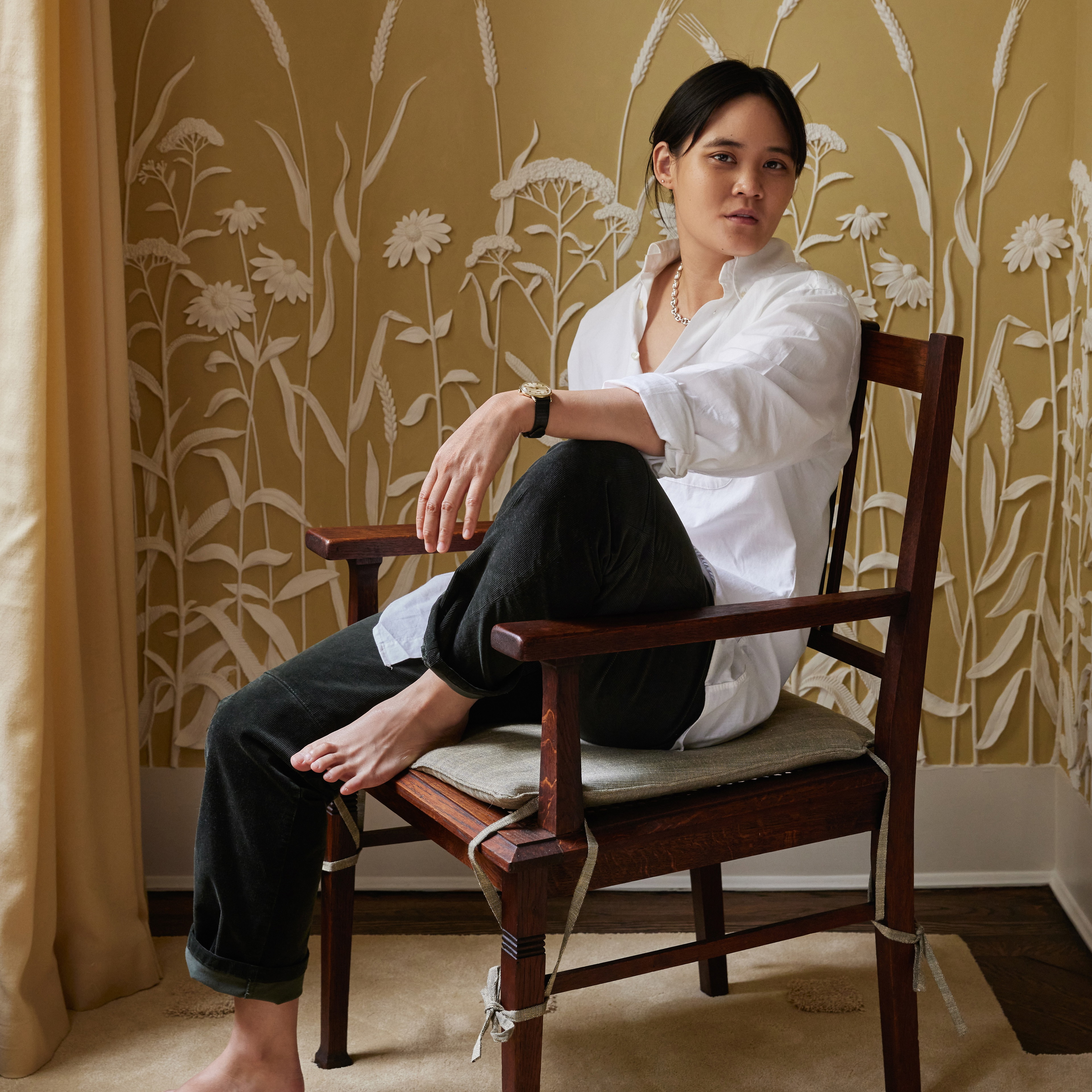 a woman sitting in a chair in front of a wall